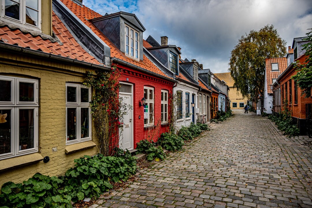 Documentary photographer walking through a cobblestone street in a Danish town