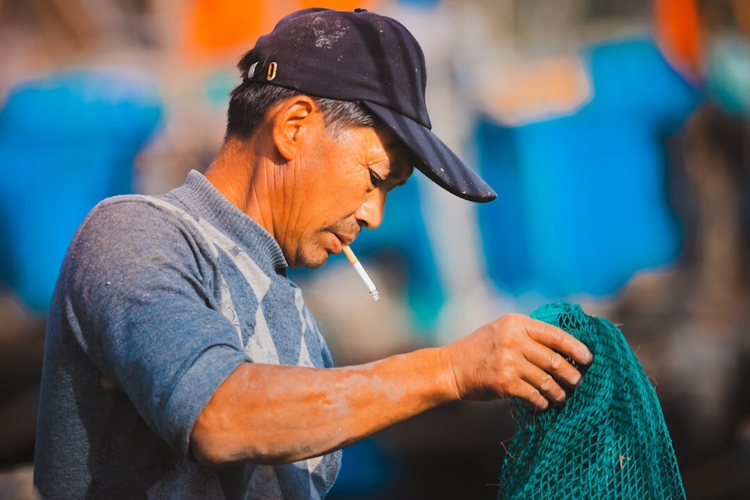 elderly man fishing net repair